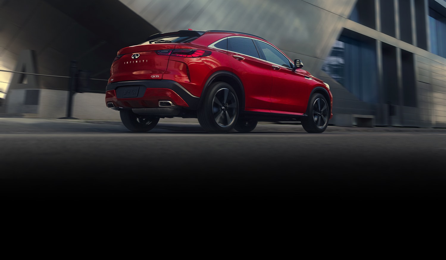 A red 2022 Infiniti QX55 driving down the road