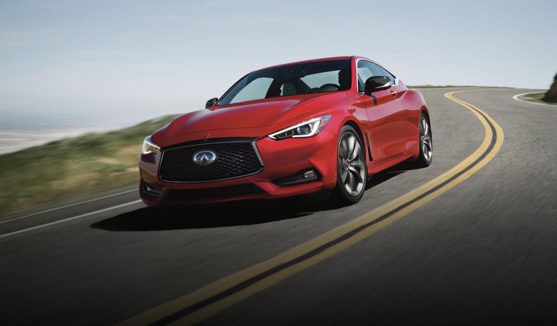 A red 2022 Infiniti Q60 driving down the road