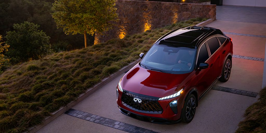Red Infiniti QX65 SUV parked on a driveway at dusk.
