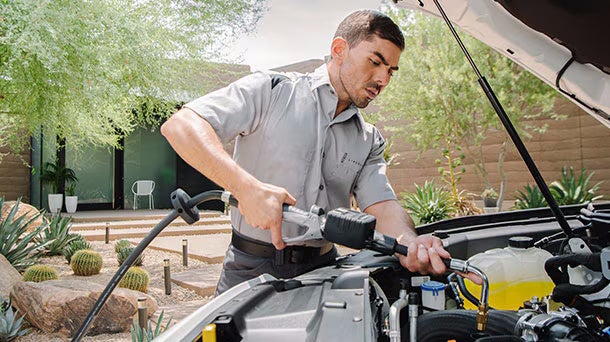Mechanic checking a car engine under the hood.
